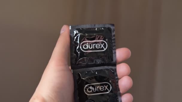 Tyumen, Russia-April 22, 2021: το χέρι κρατά ένα κουτί προφυλακτικά μάρκας Durex. — Αρχείο Βίντεο