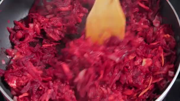 Готувати суміші подрібненої цибулі натертого буряка і помідорів в сковороді. приготування домашньої їжі — стокове відео