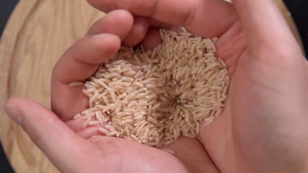 Uncooked brown rice. Race are different from brown see other high nutritious. slow motion — Stock Video