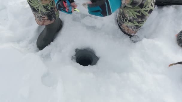 Balıkçı donmuş gölde balık tutuyor. Nehirde kış dondurucu sabah balıkçılığı. yavaş çekim — Stok video