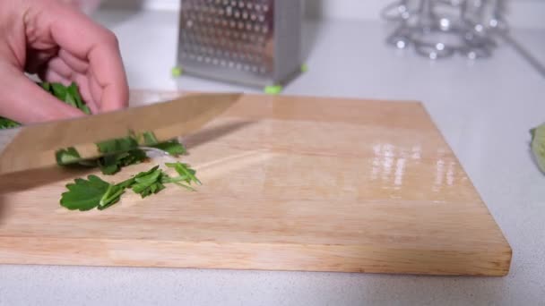 Fette di prezzemolo con un coltello da cucina su una tavola di legno. focus selettivo — Video Stock