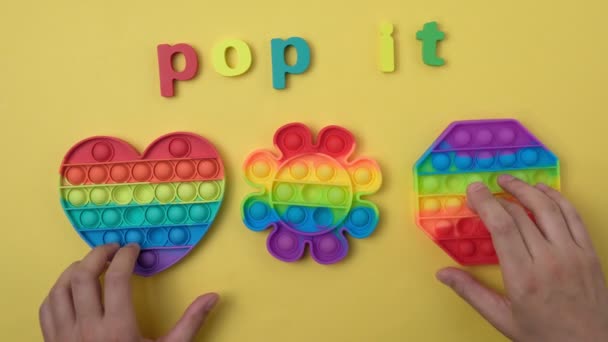 Bunte antistress sensorische Spielzeug Fidget Push Pop es. Auf gelbem Hintergrund — Stockvideo