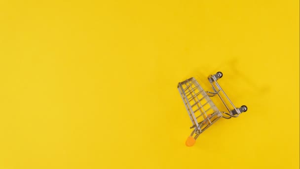 Carrello della spesa su sfondo giallo. Venerdì nero e concetto di pubblicità. Simbolo dello shopping. Ferma movimento. — Video Stock