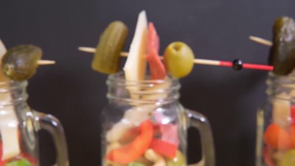 Jarcuterie Snacks in transparent jars cheese ham olives lettuce cucumbers nuts. — Stock Video