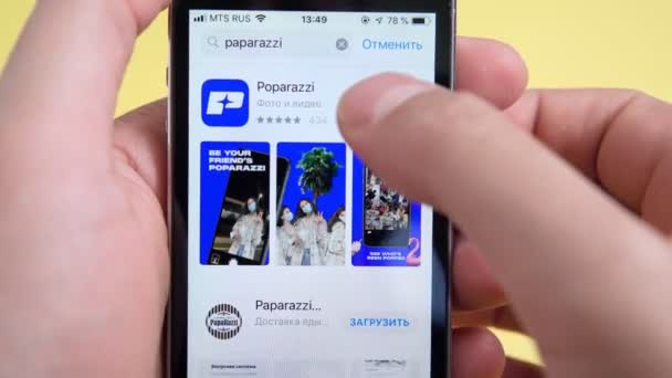 Tyumen, Rusland-4 juni 2021: Open app Poparazzi op smartphone in handen mannen — Stockvideo