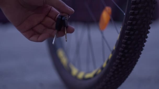 Sleutels van het fietsslot liggen in de hand van de mens. selectieve focusavondtijd — Stockvideo