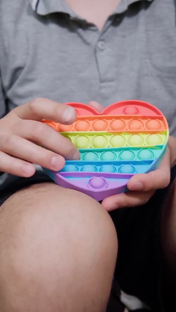 Regenbogen-Anti-Stress-Spielzeug zappeln. Silikonspielzeug Antistress Pop es. Vertikales Video — Stockvideo