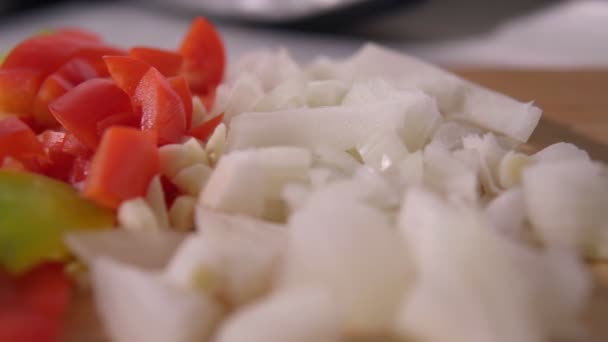 Skivning grönsaker för vegetarisk sallad. Lök, paprika på ett träbord. — Stockvideo