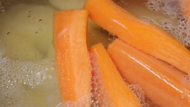 Zanahorias hirviendo en agua caliente de cerca, enfoque selectivo — Vídeo de stock