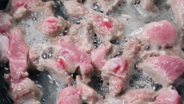 Ev mutfağında sıcak tava pişiren domuz eti şeritleri. Akşam yemeği için pişirildi — Stok video