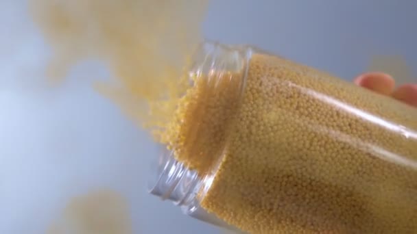 Pours grits of millet close-up cooking. selective focus. slow motion — Stock Video