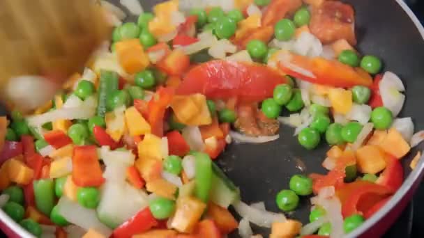 Memasak sayuran rebus close-up. kacang polong, paprika, bawang, wortel dalam wajan — Stok Video