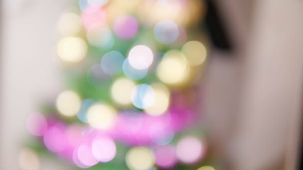 Gałęzie jodły z magicznymi lampkami świątecznymi rozpraszają girlandy świąteczne. Streszczenie Świąt Bożego Narodzenia 4k tło wideo. — Wideo stockowe