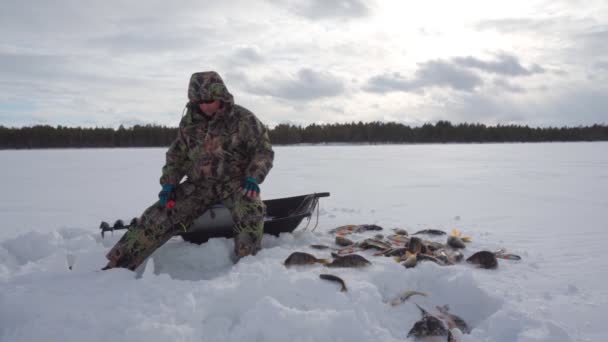 Pescatore pesca sul lago ghiacciato. Inverno ghiaccio gelido pesca — Video Stock