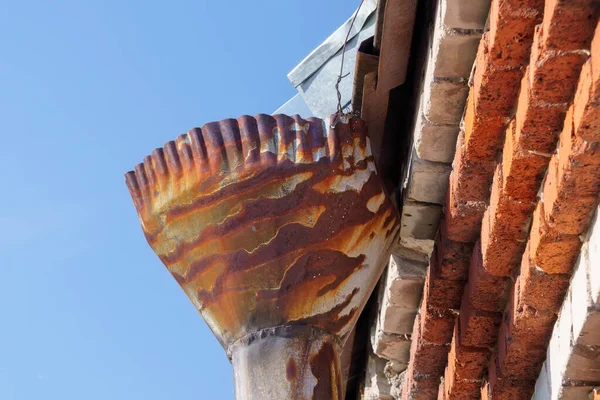 Rain gutters on old home. There is a blue sky in the background.