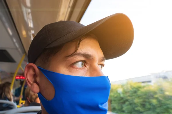 Fiatal fickó buszozik orvosi maszkkal az arcán. Tömegközlekedéssel történő utazás a járvány idején — Stock Fotó