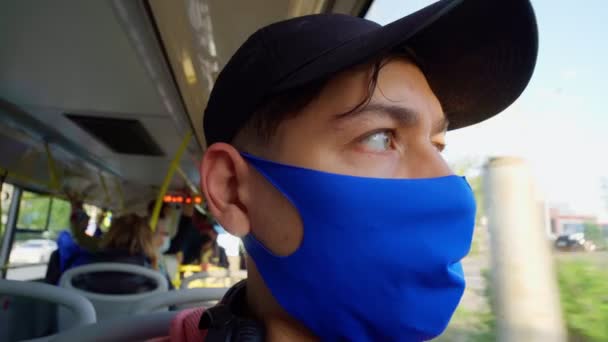 Fiatal fickó buszozik orvosi maszkkal az arcán. Tömegközlekedéssel történő utazás a járvány idején — Stock videók