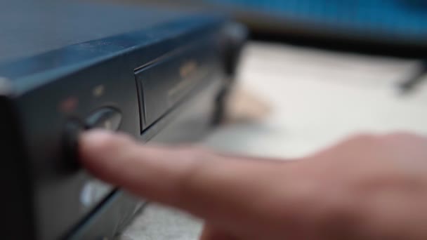 Користувач, який відтворює відеокасету VHS на старовинному VCR плеєрі. Вибірковий фокус — стокове відео