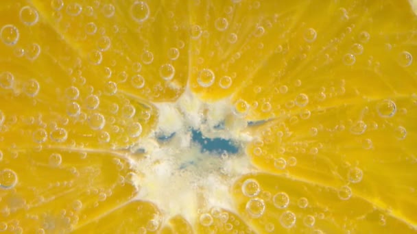 A fruta cor-de-laranja na água fecha-se, abaixo da água com bolhas. Movimento lento — Vídeo de Stock