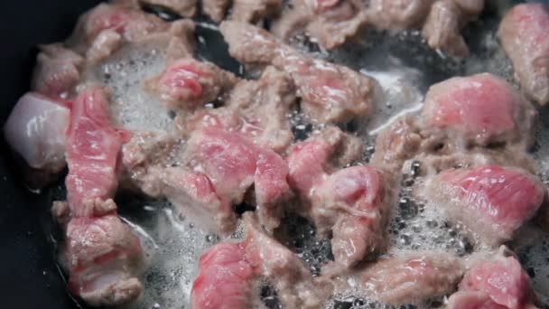 Potongan daging babi digoreng. Potongan daging mentah digoreng dalam minyak panas. Tutup. — Stok Video
