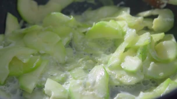 Matlagning zucchini närbild i en stekpanna. Spatel av trä för matlagning. Långsamma rörelser — Stockvideo