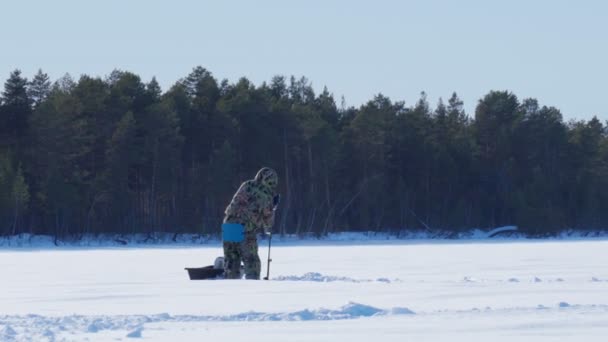 Winter fisherman on the lake catches perch on a winter fishing trip. — Stock Video