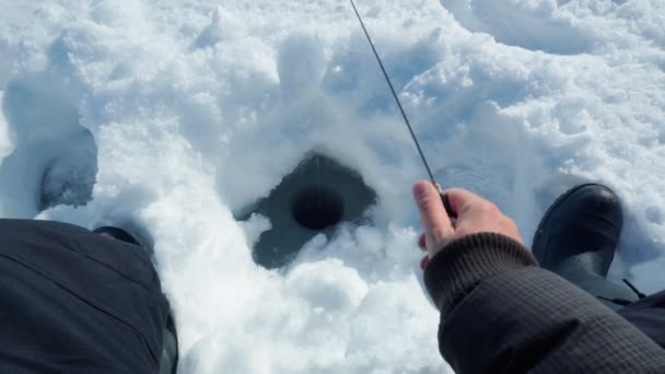Pesca sul ghiaccio. pescatore pesca sul lago ghiacciato. Inverno gelido mattina pesca sul fiume. — Video Stock