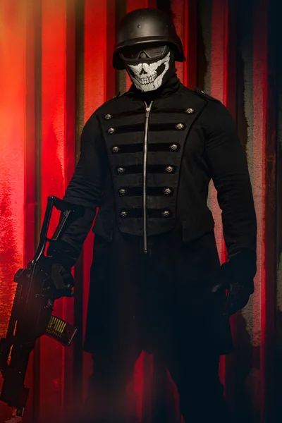 Небезпечний чоловік у масці з рушницею на червоному тлі — стокове фото