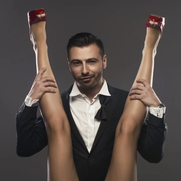 Eleganter Mann sitzt und breitet die Beine einer Frau aus — Stockfoto