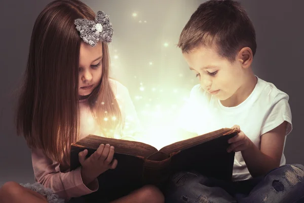 Small couple opened a magic book — Stock Photo, Image