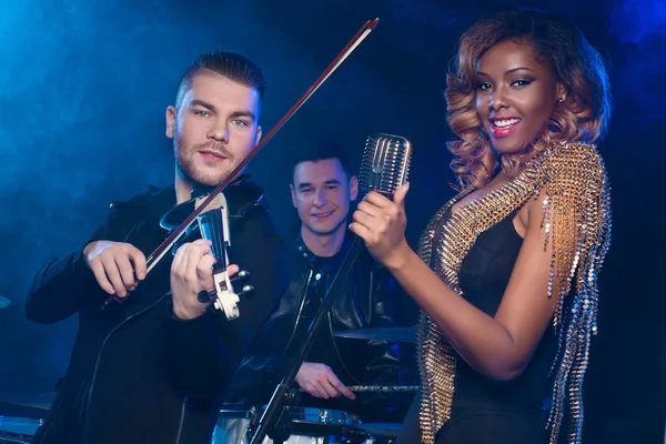 Fashionable music band posing. Two handsome man and beautiful sexy woman with music instruments — Stock Photo, Image
