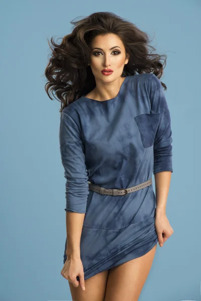 Mujer de energía en vestido azul posando en el estudio — Foto de Stock