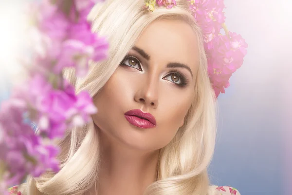 Glamoureuze bochtige blonde vrouw met een sexy lichaam poseren met bloemen — Stockfoto