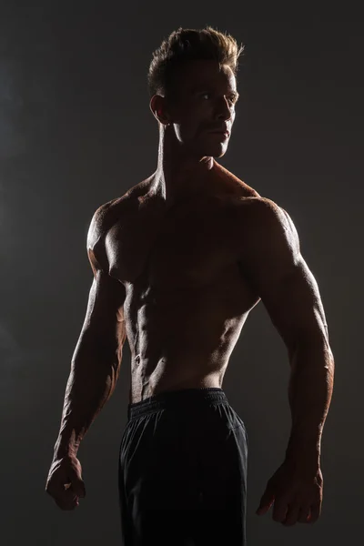 Silhouette of a muscular man in shadow — Stock Photo, Image