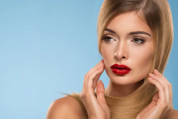 Portrait of beautiful young sexy woman with red lips, over blue background — Stock Photo, Image