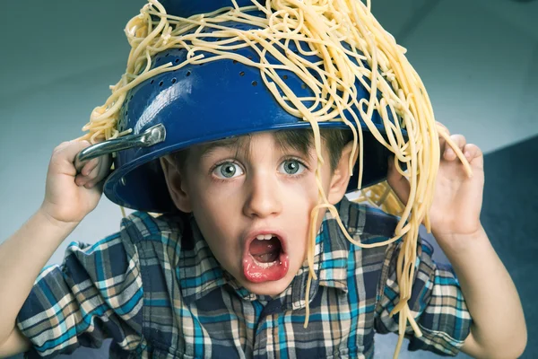 Surprised boy with pasta on the head — Stock Photo, Image