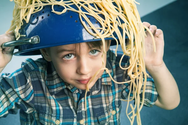 Chico sorprendido con pasta en la cabeza — Foto de Stock