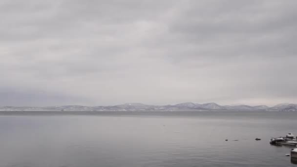 Mar tranquilo, invierno, la costa y las montañas nevadas — Vídeo de stock