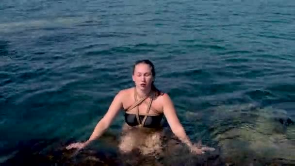 Uma Menina Amarrada Com Cordas Flutua Água Fica Sobre Pedras — Vídeo de Stock