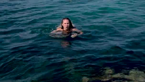 一个被绳子拴在水里站在石头上的女孩 — 图库视频影像