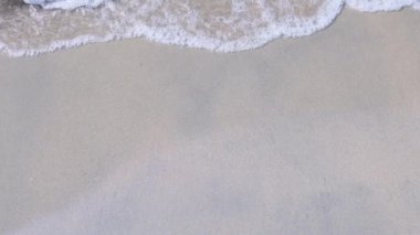 Ağır çekim, kumlu sahilde dalgalar akıyor, güneşli ve güneşli bir gün.