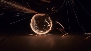 Ustabaşı bir üçkağıtçı kullanır ve karanlıkta paslanmaz çelik boruyu keser. Mühendis öğütme makinesinde çalışır ve öğütür. Parlak kıvılcımlar uçuşuyor.