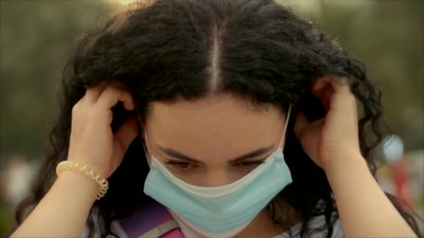 Portret van een jonge studente Vrouw met een beschermend masker op straat, met een ovid-19 masker op. Gezondheids- en veiligheidsconcept, N1H1-coronavirus, virusbescherming, pandemie. — Stockvideo