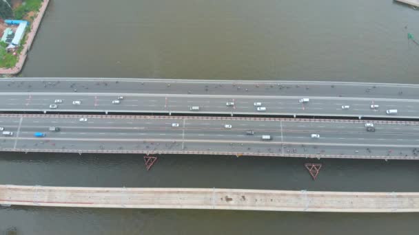 Vista aérea aérea del puente de la ciudad con coches y motocicletas sobre el telón de fondo del hermoso océano marítimo y los grandes edificios de la ciudad. Puente y autopista de ciudad. — Vídeo de stock