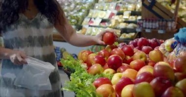 Güzel genç kadın ya da anne süpermarketten alışveriş yapıyor, süpermarketten yemek, sağlıklı yiyecekler, meyveler, elmalar, portakallar ve süpermarketten ürünler seçiyor. Alışveriş, vejetaryen