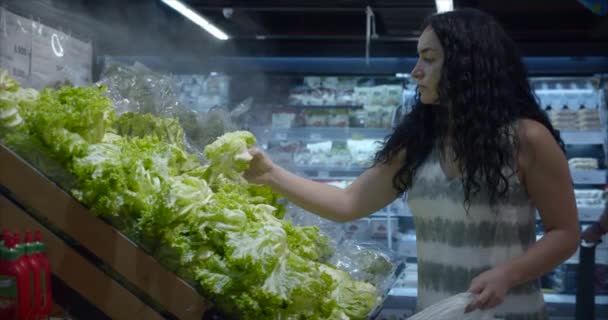 Menina faz compras no supermercado, comida saudável, salada de repolho no mercado, supermercado. Conceito de compras de supermercado. Seleção de produtos no supermercado para cozinhar. — Vídeo de Stock