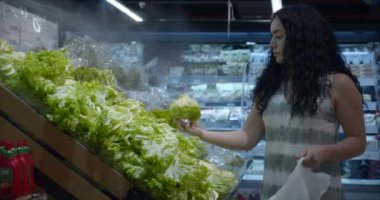 Kız süpermarketten alışveriş yapıyor, sağlıklı yiyecekler, markette lahana salatası, süpermarket. Market alışverişi konsepti. Süpermarkette yemek pişirmek için ürün seçimi.