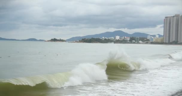 Clima nublado, lluvia, grandes nubes grises, clima sombrío, olas marinas rompen en la orilla de la playa de la ciudad en un día nublado. Imágenes de archivo de cámara lenta. — Vídeos de Stock