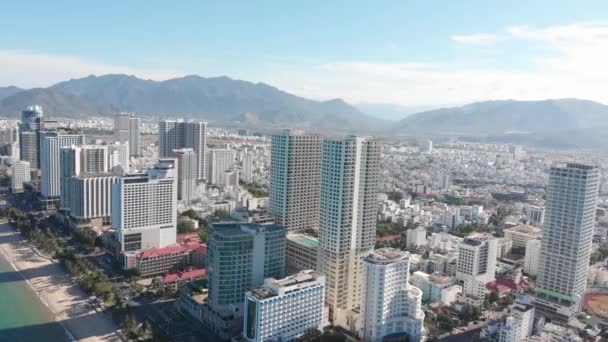 Os drones aéreos têm uma bela vista da cidade a partir de uma visão de olhos de pássaros com arranha-céus ou edifícios altos contra o pano de fundo de um belo mar azul. 4K. — Vídeo de Stock