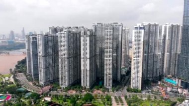 Güneşli bir sabahın erken saatlerinde şehrin üzerinde insansız hava aracı uçurmak, şehir arabalarından ve motosikletlerden çıkan dumanlar, şehir sokaklarını ve büyük şehir binalarını görmek. HO CHI MINH ŞEHRİ, VİETNAM EKİM 11. 2020